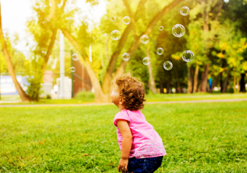 child chasing bubbles