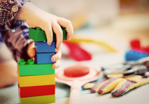 Young child with hands on blocks Learning Through Play concept