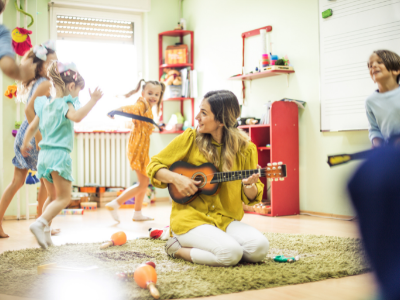 Woman playing an instrument while kids dance