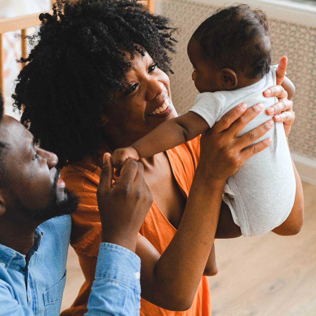 parents holding baby