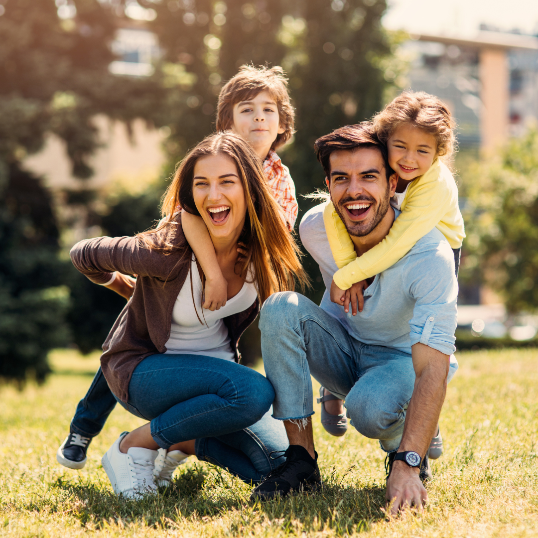 Father, mother, son and daughter smiling in a field