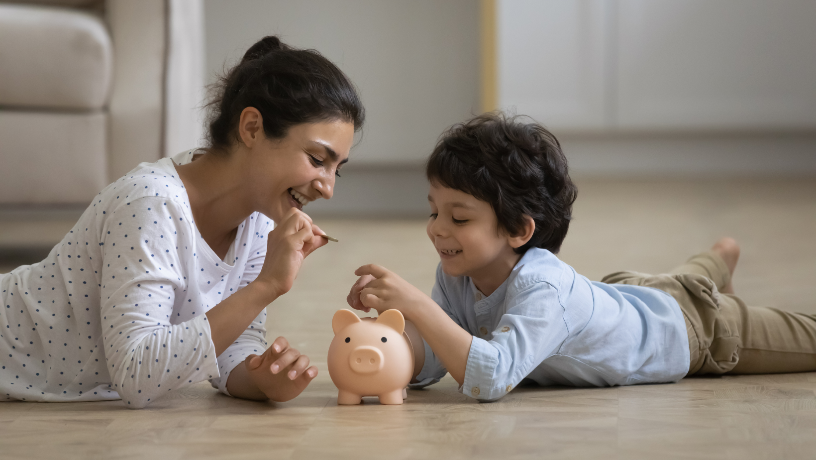 Mom and child putting money into a piggy bank