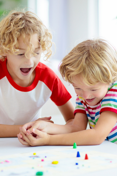 Young brothers or boys playing a board game from a busy bag
