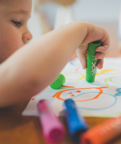 Toddler coloring with markers or dot markers from an art busy bag