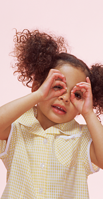 Young Girl playing I spy with her hands in circles or binoculars around her eyes