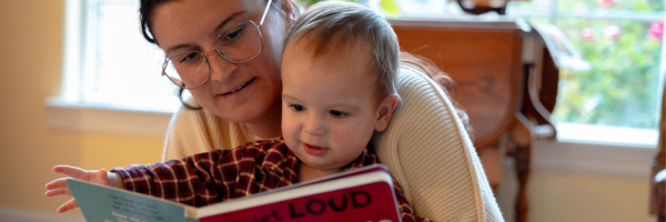 Mom and young daughter reading a book together