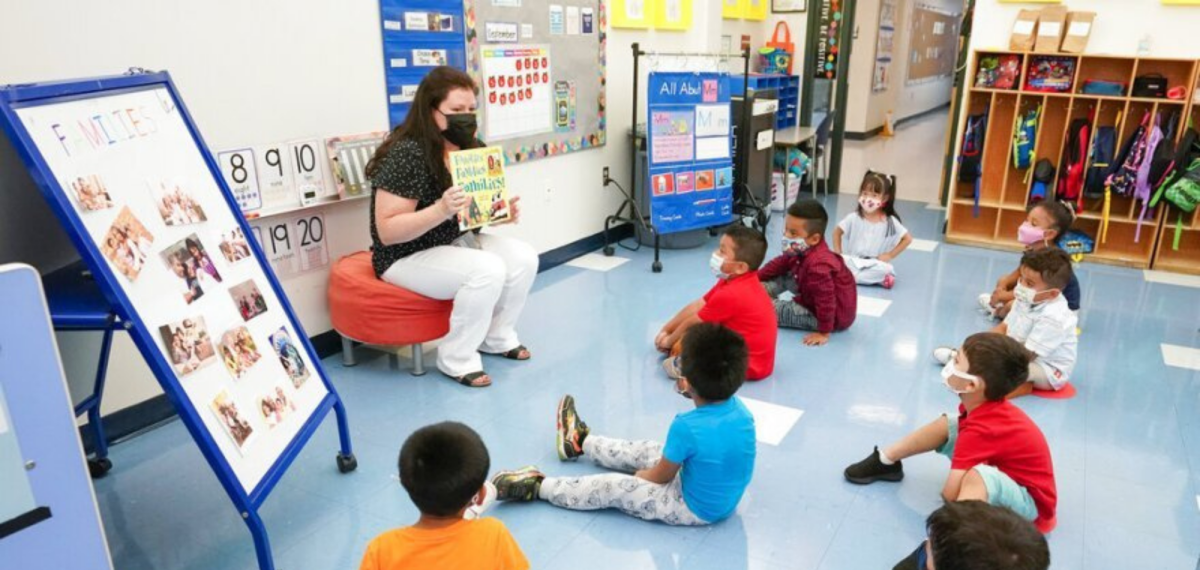 woman reading book to children