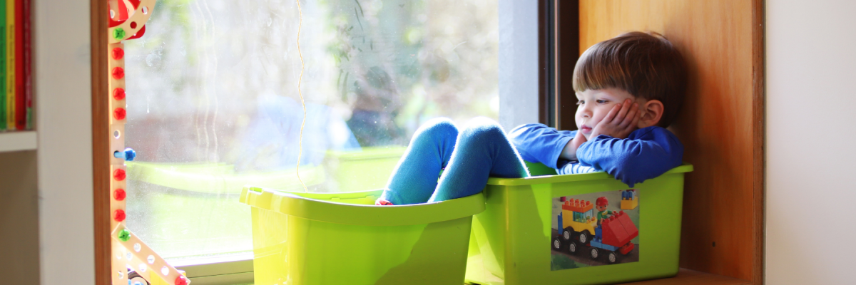 Little boy sitting in buckets on a windowsill - waiting concept or waiting is hard concept 