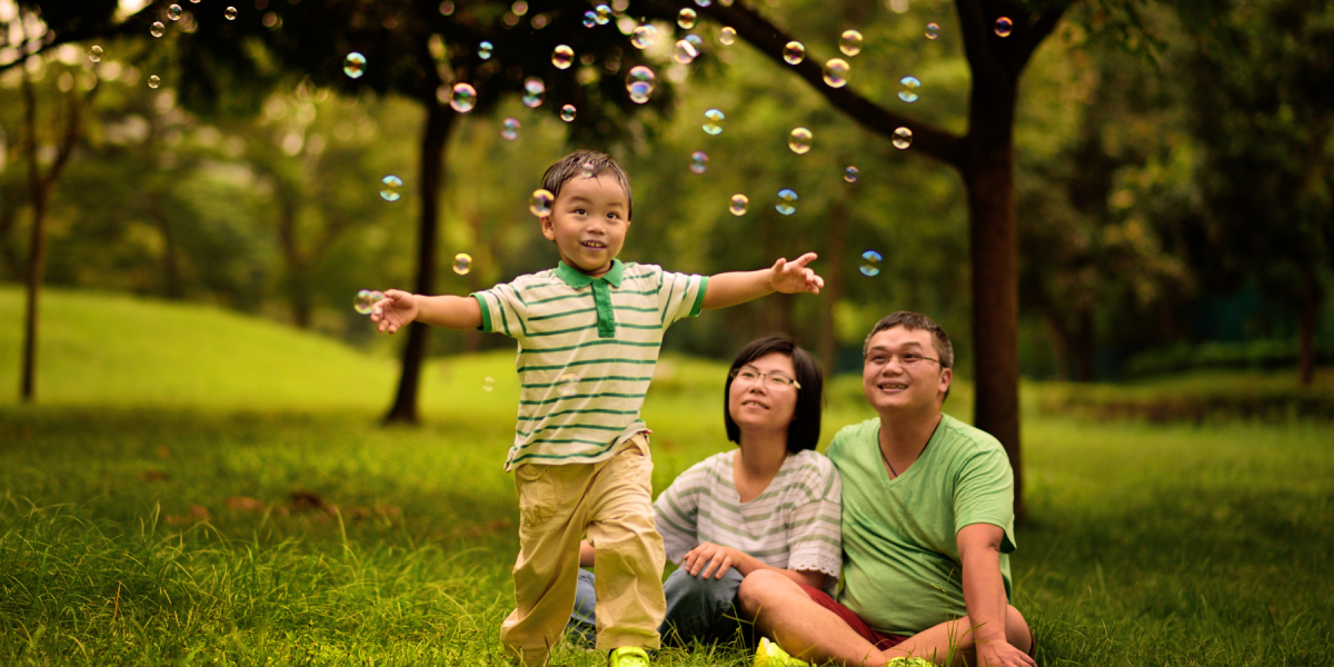 Child playing with bubbles while parents watch