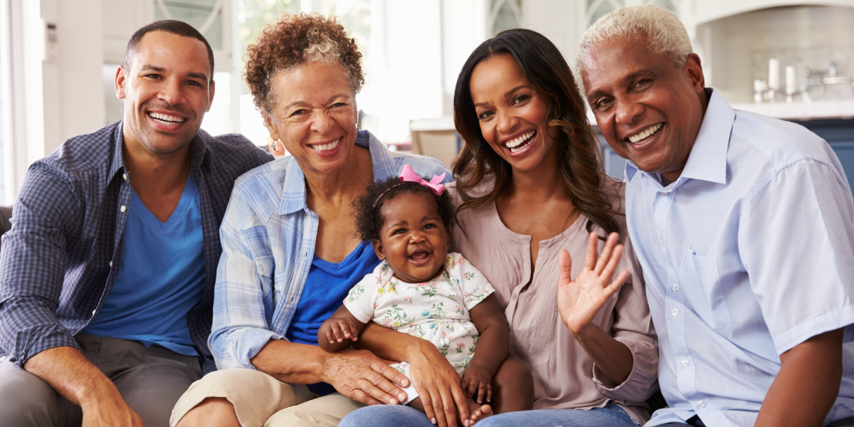 parents and grandparents holding baby